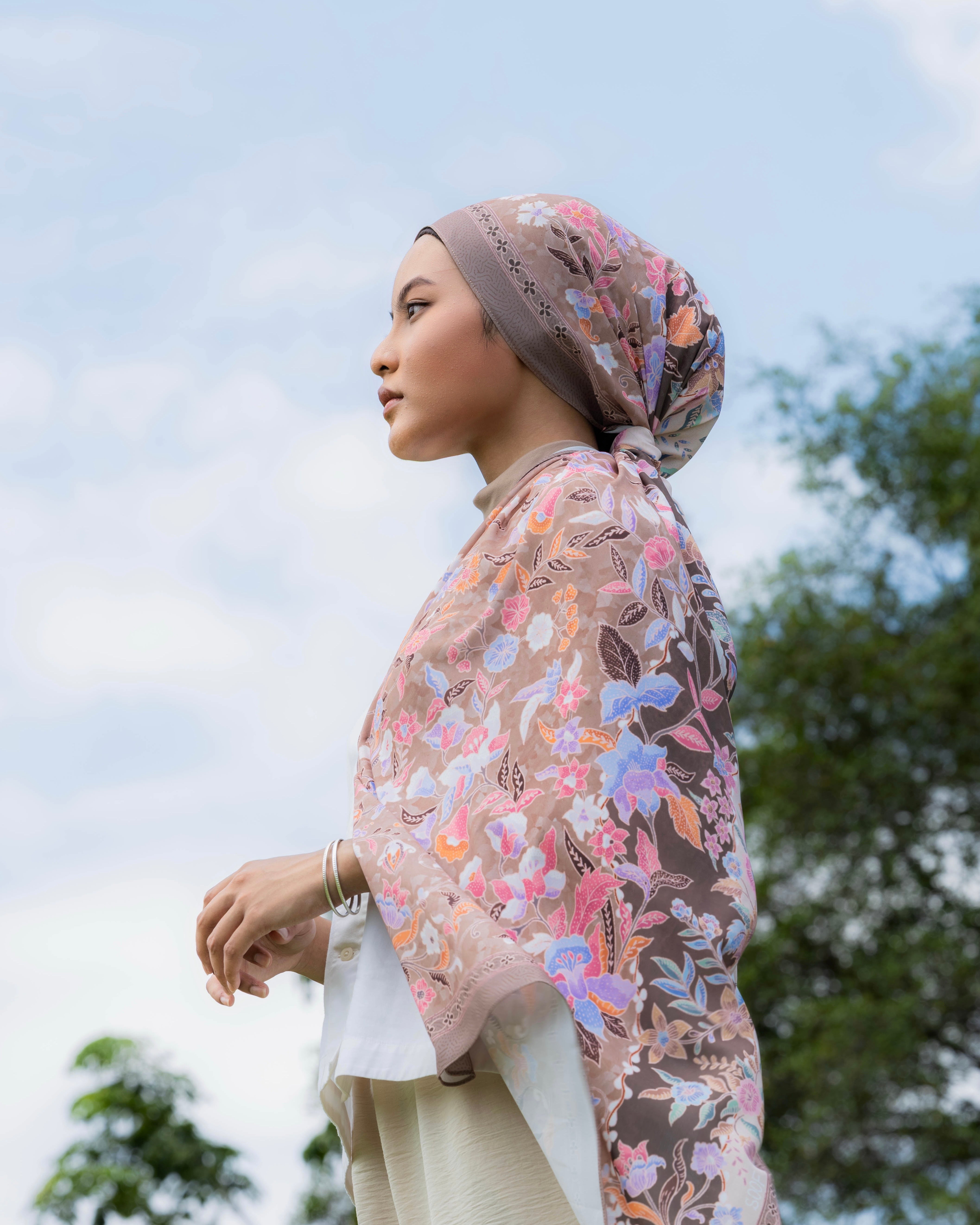 Woman wearing a Soof Sarung in Huda floral chiffon headscarf.