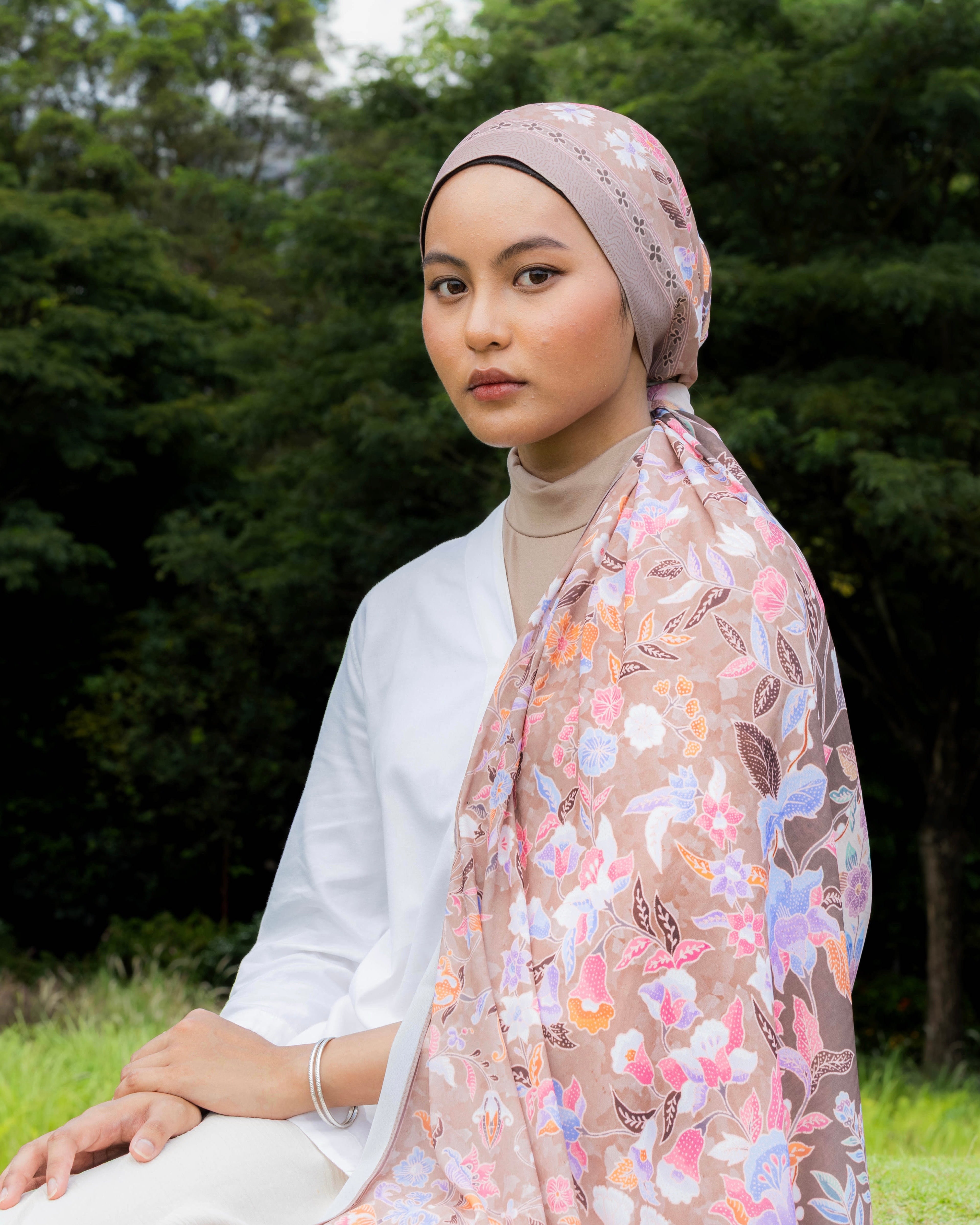 Woman wearing a Soof Sarung in Huda floral chiffon headscarf.