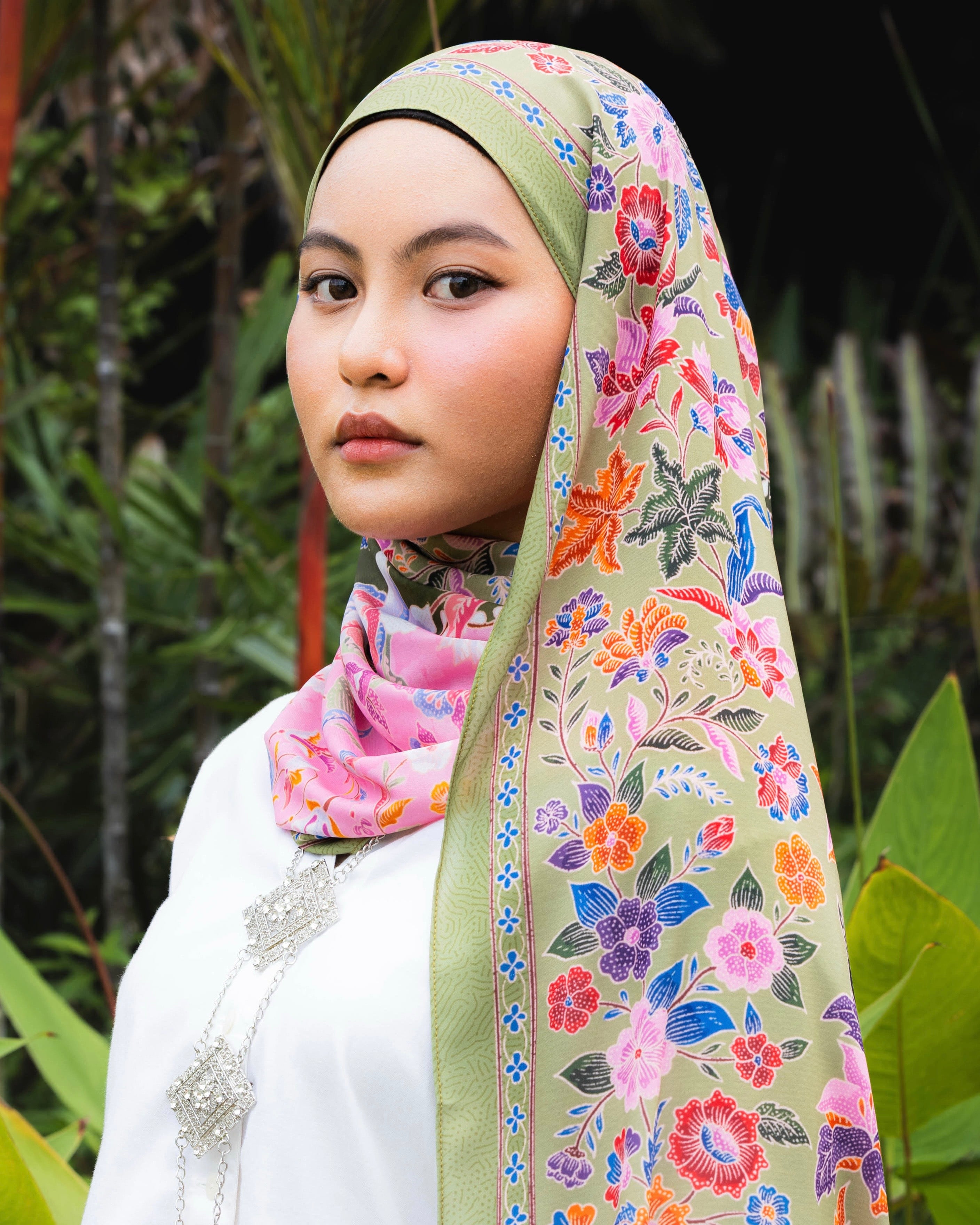 Woman wearing a Soof Sarung in Rasyidah floral chiffon, pink and green headscarf.