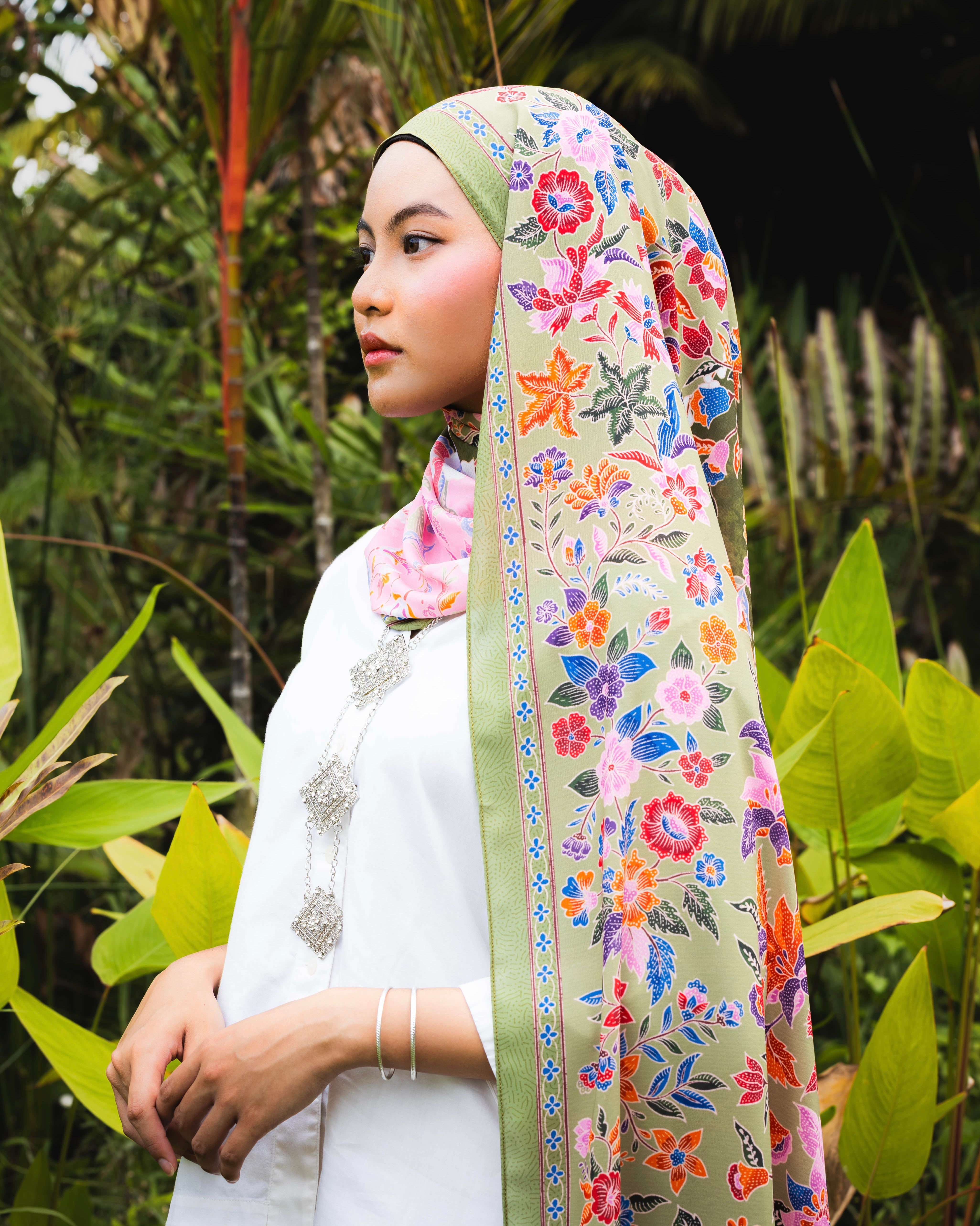 Woman wearing a Soof Sarung in Rasyidah floral chiffon, pink and green headscarf.