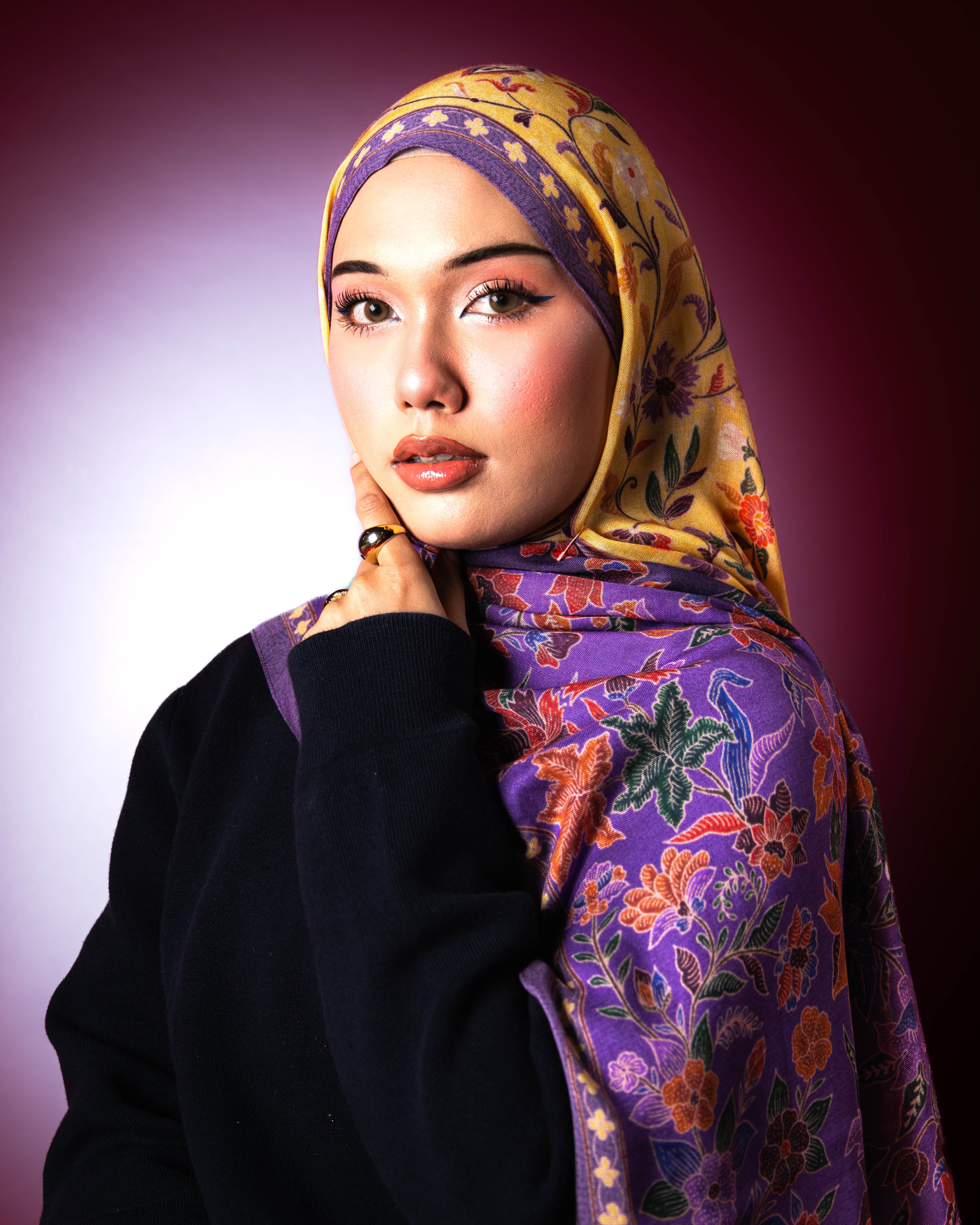 Woman wearing a Soof Sarung in Embun floral modal shawl, purple and yellow headscarf. 