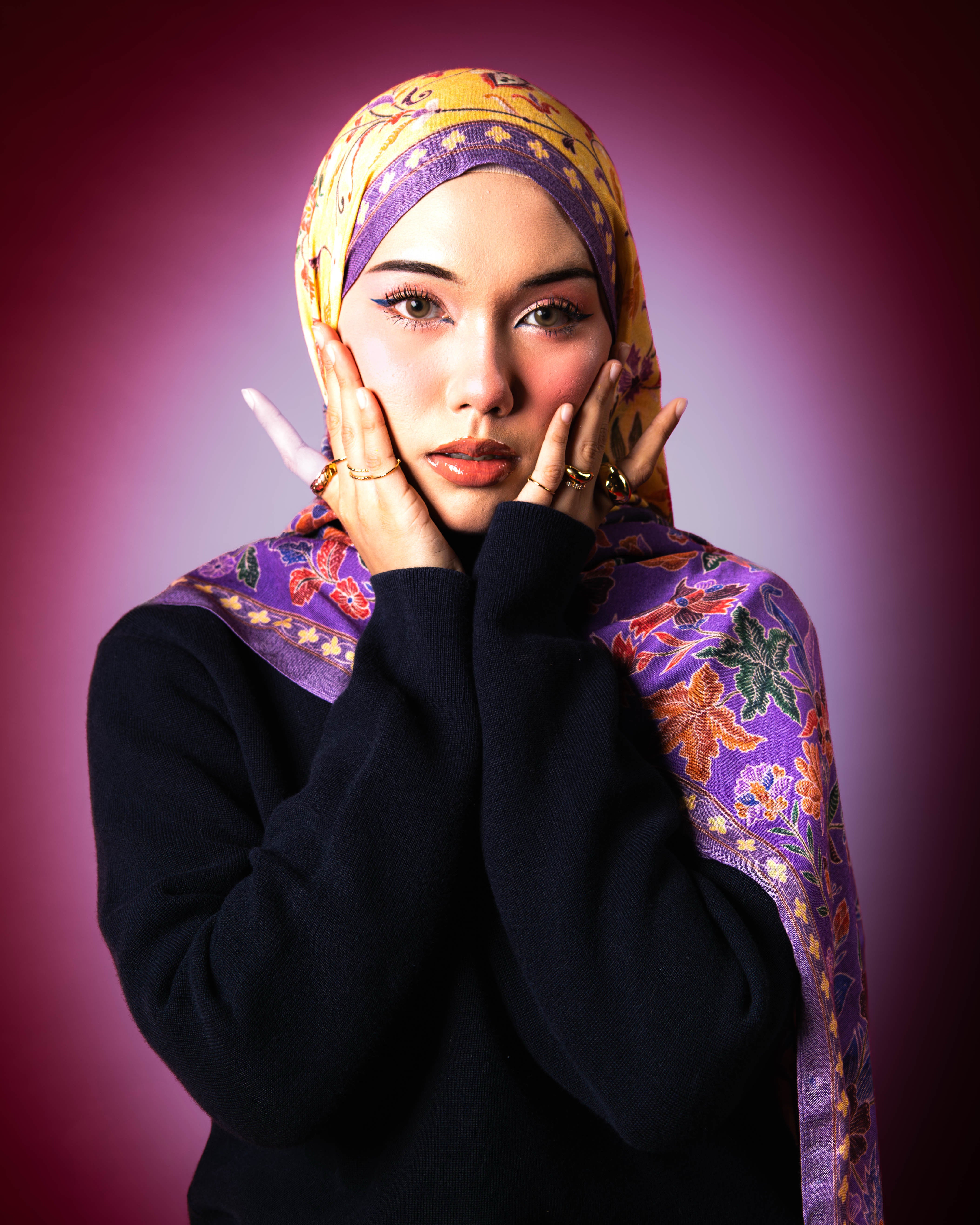 Woman wearing a Soof Sarung in Embun floral modal shawl, purple and yellow headscarf. 