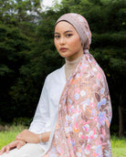 Woman wearing a Soof Sarung in Huda floral chiffon headscarf. 